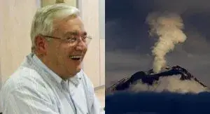 Hombre sonriendo junto a un volcán con humo.