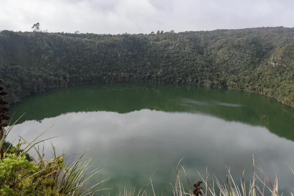 Vista del Lago Guatavita rodeado de vegetación.