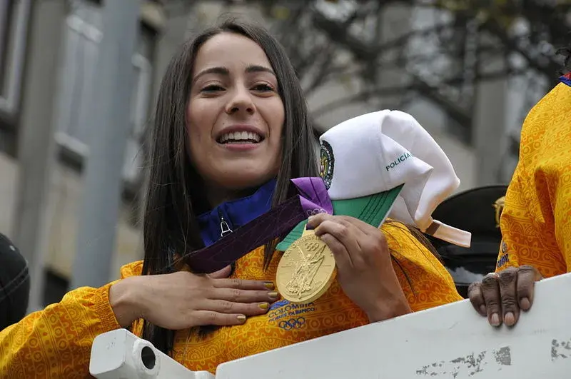 Mariana Pajón sonriendo y mostrando su medalla de oro olímpica.