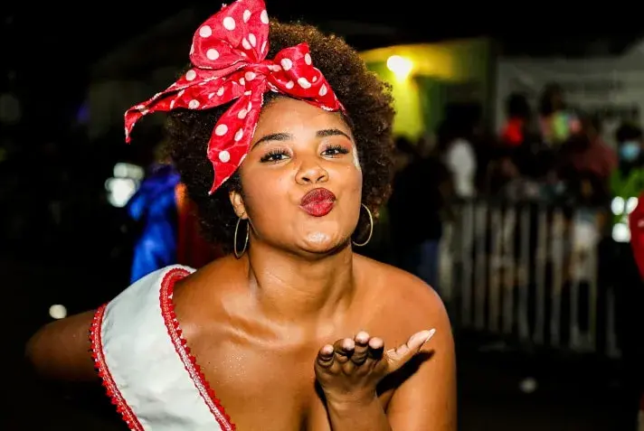 Mujer enviando un beso en el Carnaval de Barranquilla.