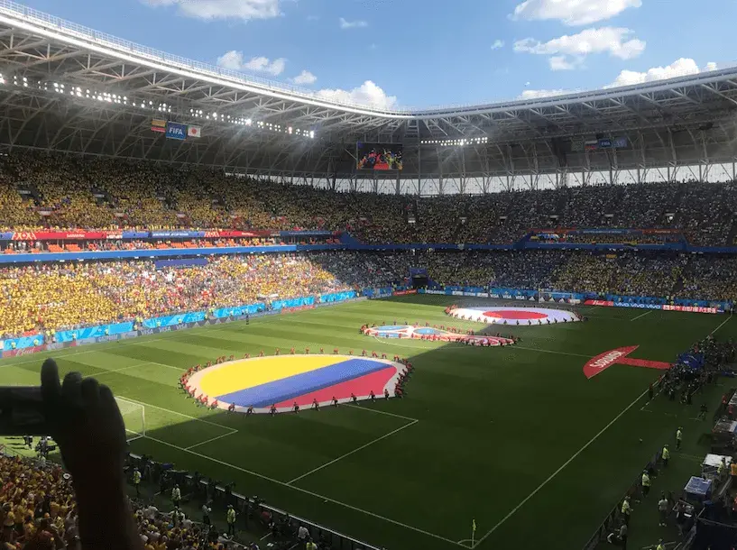 Estadio lleno en el Mundial 2018 con banderas de Colombia y Japón antes del partido.