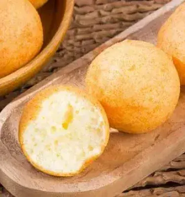 Buñuelos colombianos fritos y dorados, uno partido a la mitad.