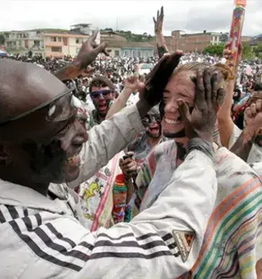 Personas se pintan el rostro con alegría en el carnaval de negros y blancos.