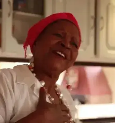 Mujer afrocolombiana sonriendo en una cocina. ¡Qué alegría transmite su sonrisa!