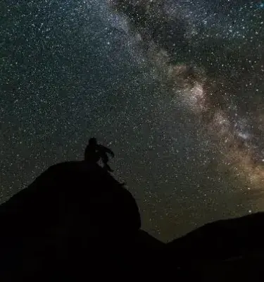 Silueta de persona observando la Vía Láctea en la noche. ¡Espectacular vista del cielo nocturno!